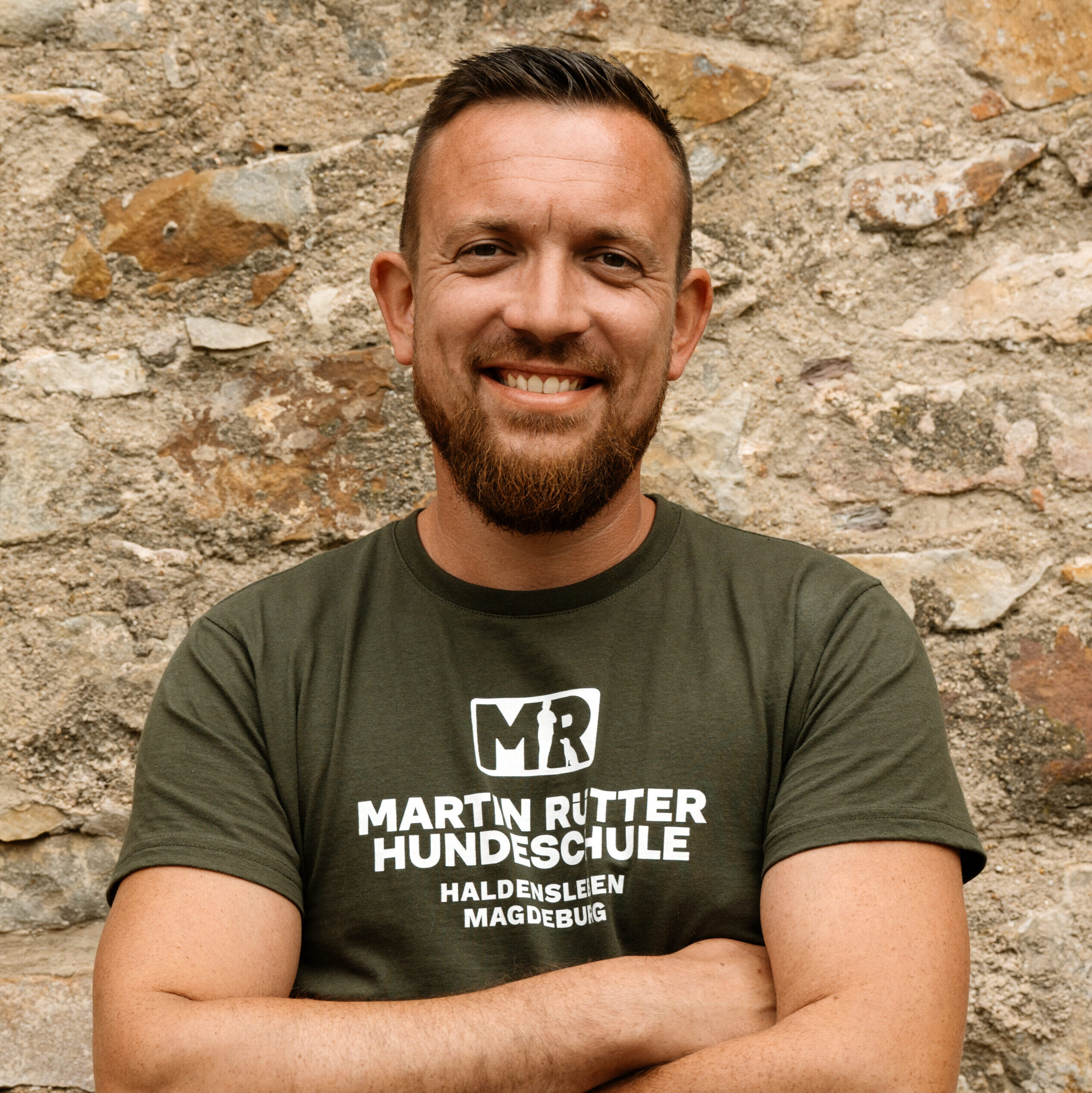 Ein Mann mit verschränkten Armen schaut in die Kamera.